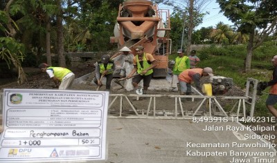 Proses pengerjaan penghamparan beton di Jalan Raya Kalipait Sidorejo, Kec. Purwoharjo, Banyuwangi.