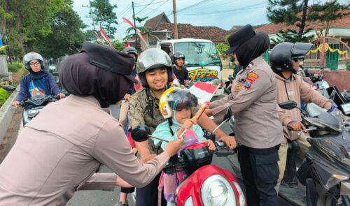 Hari Jadi ke-77, Polwan Polresta Banyuwangi Berbagi Cokelat dan Bendera di Jalan di Banyuwangi