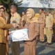 Kepala Diskominfo Jatim, Sherlita Ratna Dewi Agustin memberikan penghargaan saat apel pagi yang digelar di halaman Kantor Diskominfo Jatim, Surabaya, Senin (20/7/2026).